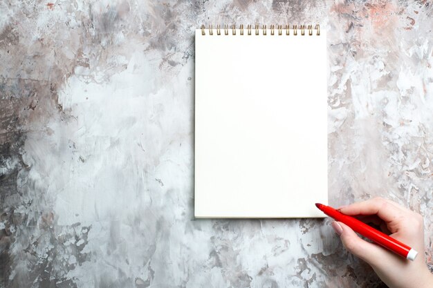 Top view of open notepad with female drawing on it on white surface