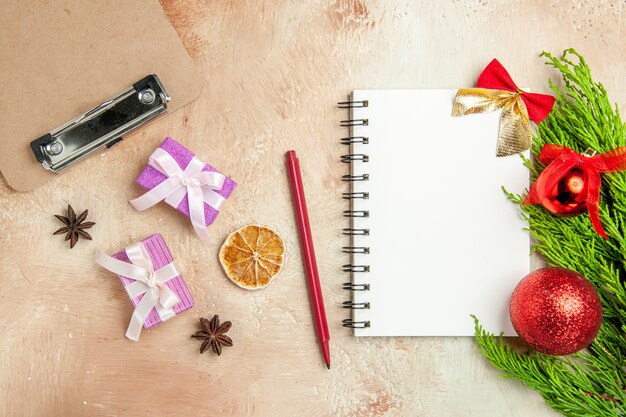 Top view open notepad with green branch and presents