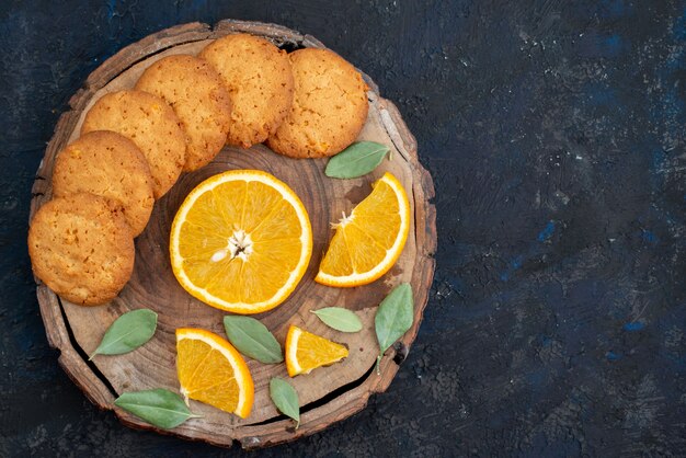 A top view orange flavored cookies with fresh orange slices on the dark background cookie biscuit sugar  fruit