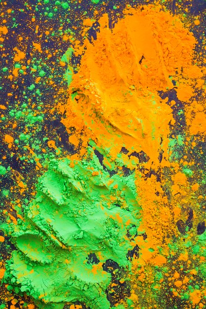 Holi 파우더 배경의 주황색과 녹색 튄의 상위 뷰
