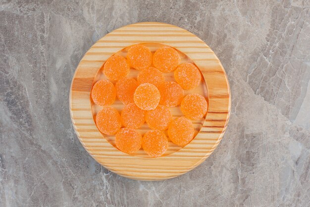 木の板にオレンジ色のゼリーキャンディーの上面図。