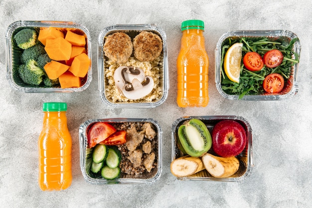 Top view of orange juice bottles with meals in casseroles