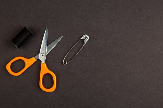 top view orange scissors on dark background