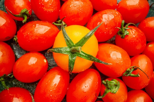 暗い背景の木の果物の写真にトマトとオレンジ色のトマトの上面図は新鮮な色を味わう