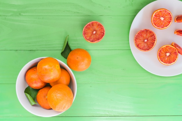 Free photo top view oranges in bowl and plate