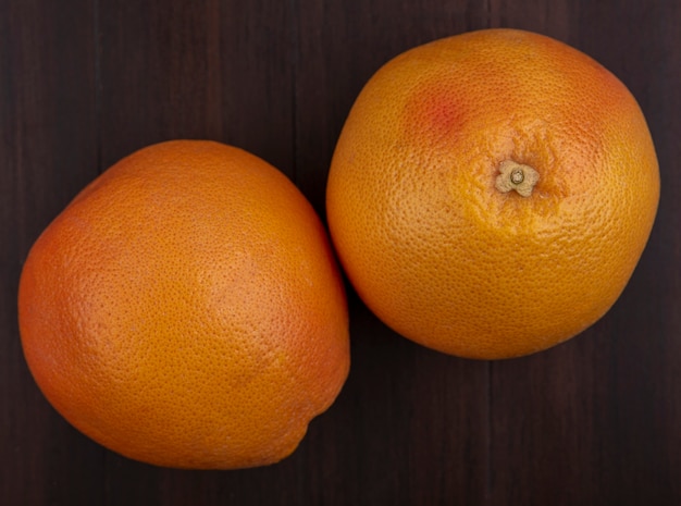 Free photo top view oranges on wooden background