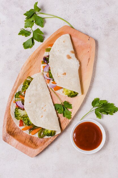 Top view of organic vegetables wrapped in pita with sauce