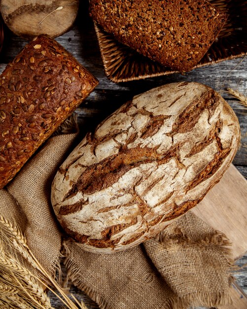 Top view of organic whole grain breads placed on linen fabric