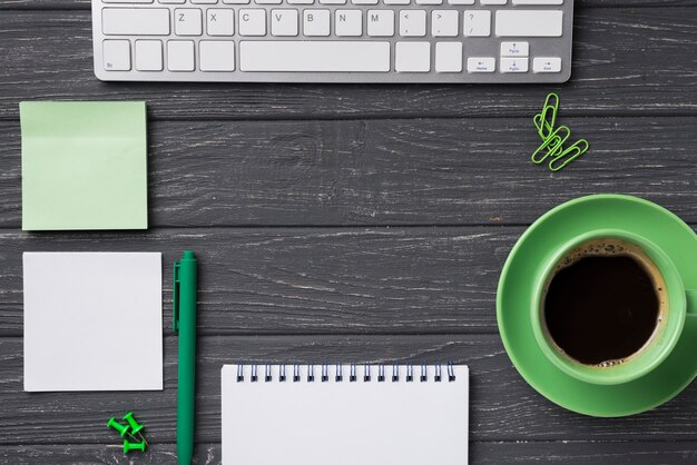 Top view of organized desk with coffee cup and notebook