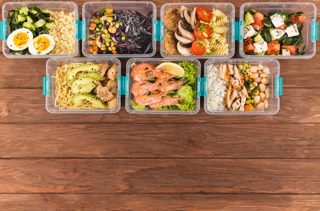 Top view of organized plastic food containers with meals