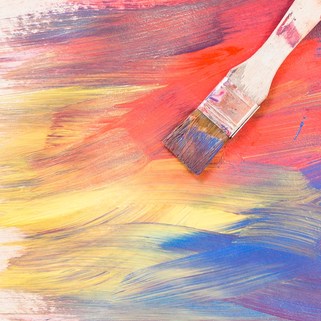 Free photo top view of paint brush on bright colorful brush stroke textured