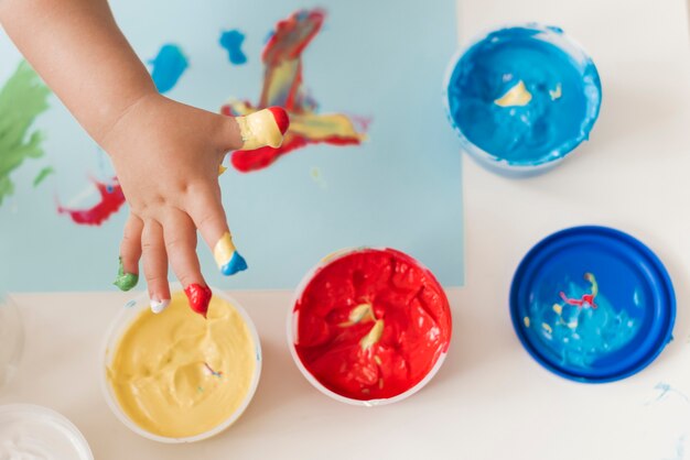Top view of paint and child hands