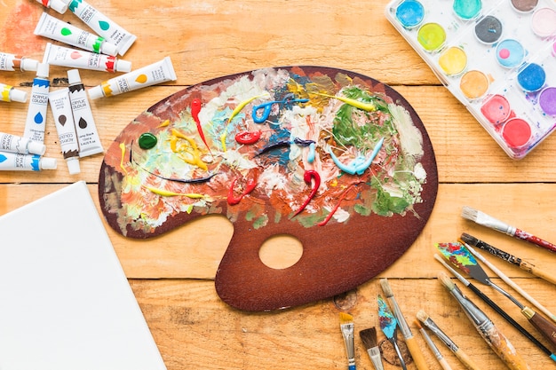 Top view paint palette surrounded by painting material