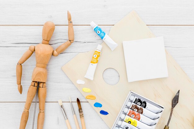 Top view paint supplies with wooden mannequin