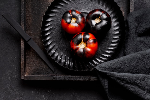Вид сверху нарисованные черные печеные помидоры на тарелке