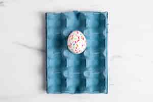 Free photo top view of painted easter egg in carton