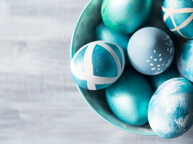 Top view of painted easter eggs in bowl with copy space