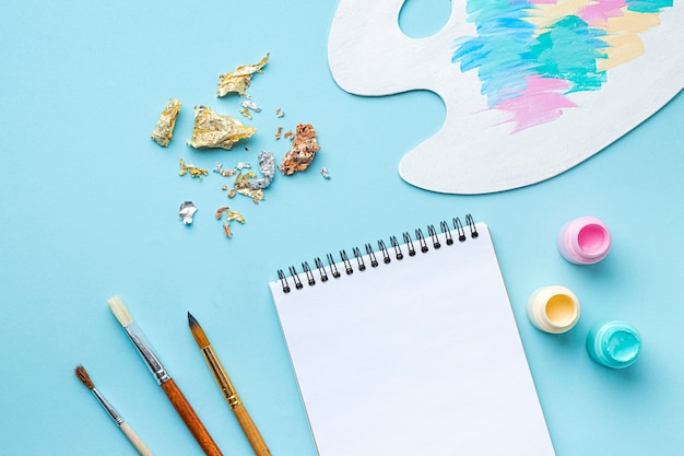 Top view of painting set with palette and notebook