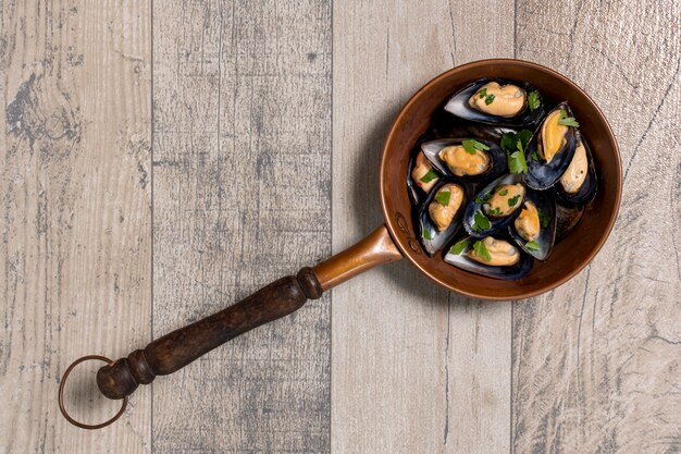 Top view pan with mussel shells and parsley