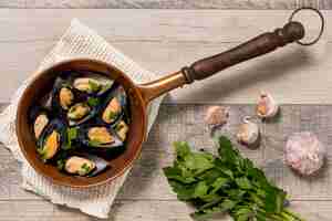 Free photo top view pan with mussels and parsley