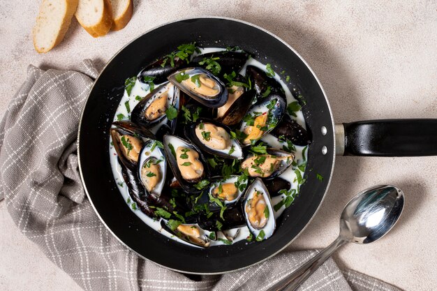 Top view pan with sauce and mussels