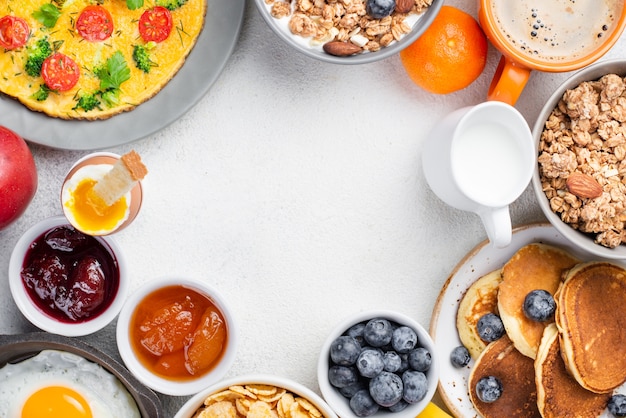 Top view of pancakes and omelette with jam and blueberries for breakfast