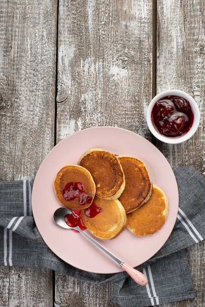 Top view of pancakes on plate for breakfast with jam and spoon