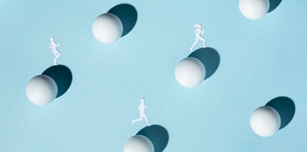 Top view of paper athletes with ping pong balls