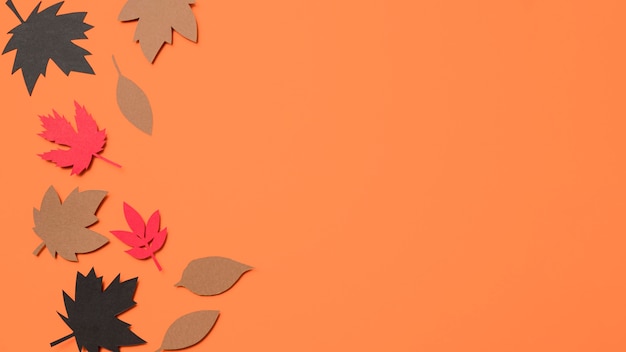 Вид сверху бумаги осенние листья на оранжевом фоне с копией пространства