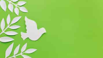 Free photo top view of paper dove and leaves with copy space