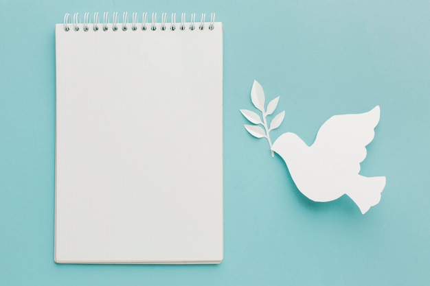 Free photo top view of paper dove with notebook