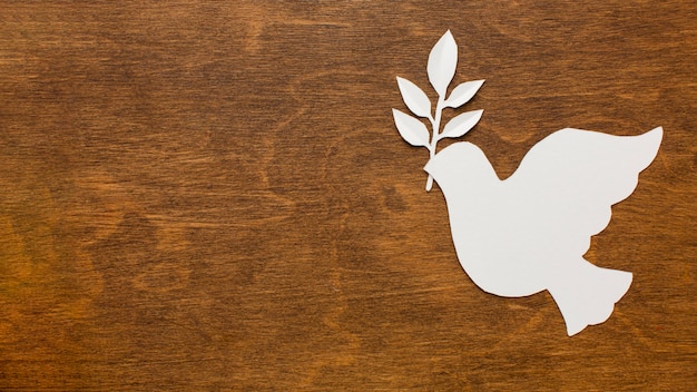 Top view of paper dove on wooden surface with copy space