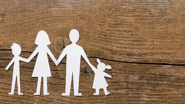 Top view paper family composition on wooden background with copy space