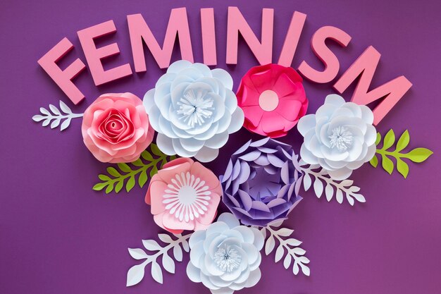 Top view of paper flowers with the word feminism for women's day