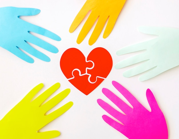 Top view of paper hands with puzzle paper heart