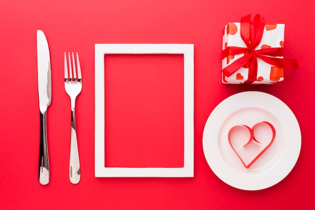 Free photo top view of paper heart shape on plate with frame and cutlery