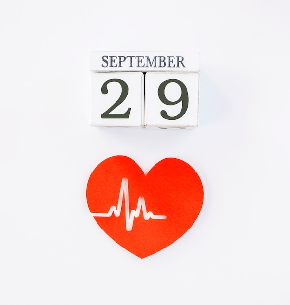 Free photo top view of paper heart with heartbeat and date