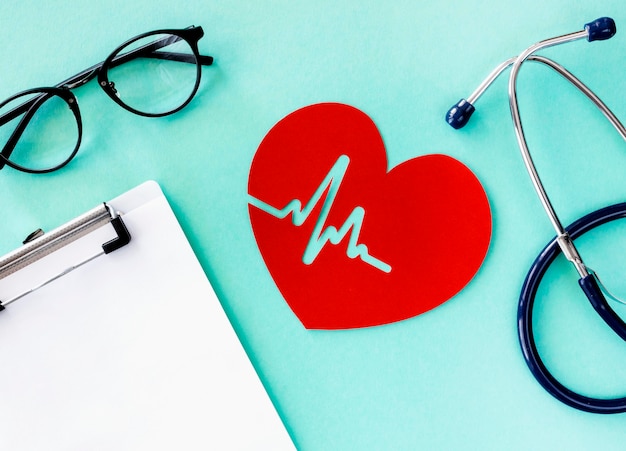 Top view of paper heart with heartbeat and stethoscope