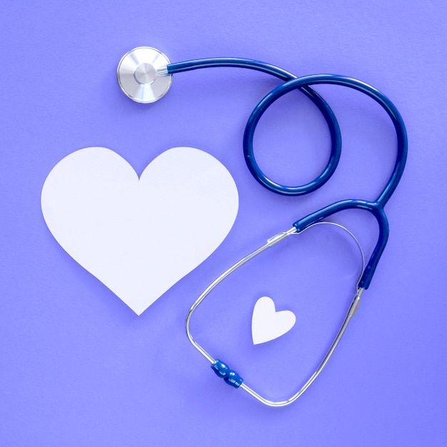 Free photo top view of paper heart with stethoscope