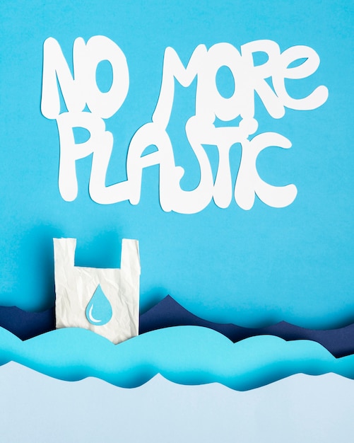 Top view of paper ocean waves with plastic bag and message