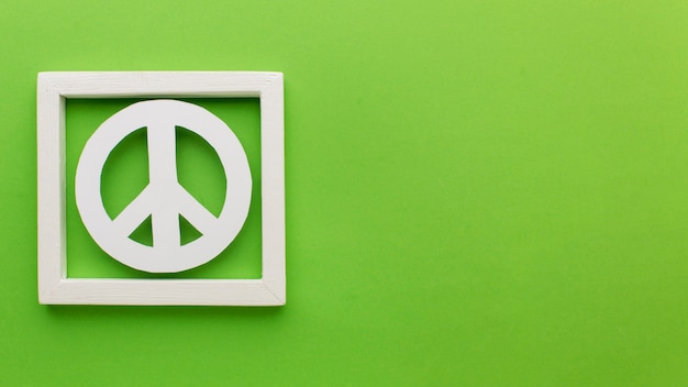 Free photo top view of paper peace sign in frame with copy space