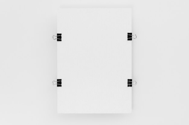 Top view of paper with metal clips on sides