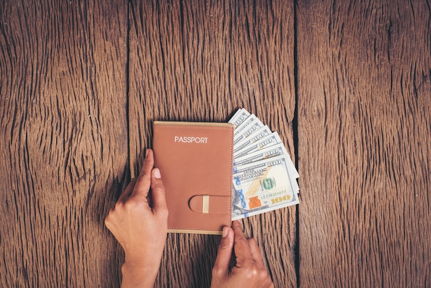 Top view passport with money on wood background, tourism concept