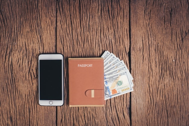 Top view passport with money on wood background, tourism concept