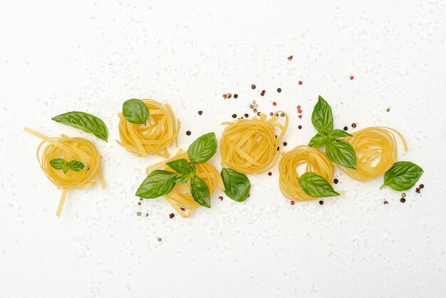 Top view of pasta and basil on plain background