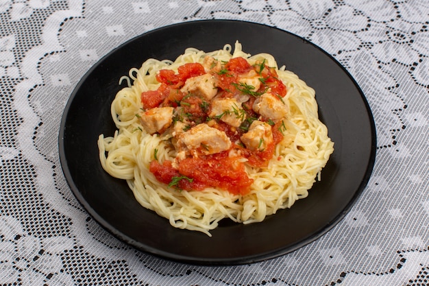 вид сверху паста вкусно приготовленная с куриными крылышками и томатным соусом внутри черной тарелки на столе