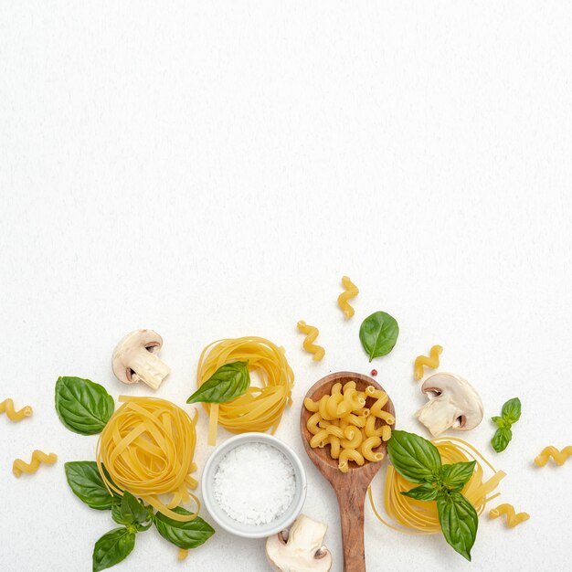 Top view of pasta and salt on plain background with copy space