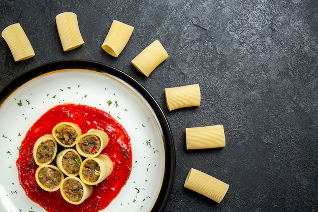 Foto gratuita vista dall'alto pasta con carne e salsa di pomodoro su uno sfondo grigio pasta di pasta di carne pasta alimentare