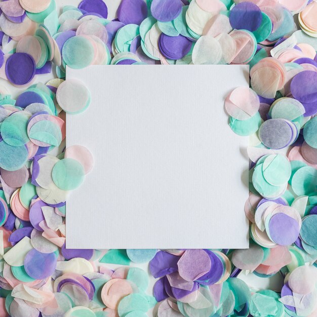 Top view pastel color confetti with paper in the middle