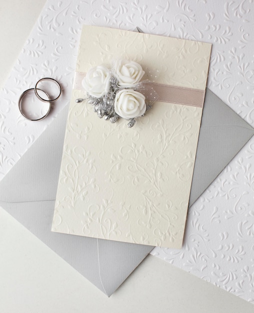 Top view pastel coloured wedding invitations and rings